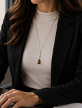 Frau trägt verstellbare Y-Halskette in Silber mit Tigerauge-Tropfenanhänger und Silbertropfen über schwarzem Blazer – elegante lange Damenkette, moderner Luxusschmuck