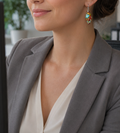 Frau trägt bunte Jaspis Tropfenohrringe mit grauem Blazer – farbenfroher Naturstein-Boho-Schmuck in Rot, Gelb und Türkis, elegantes Statement-Accessoire für Alltag und Büro